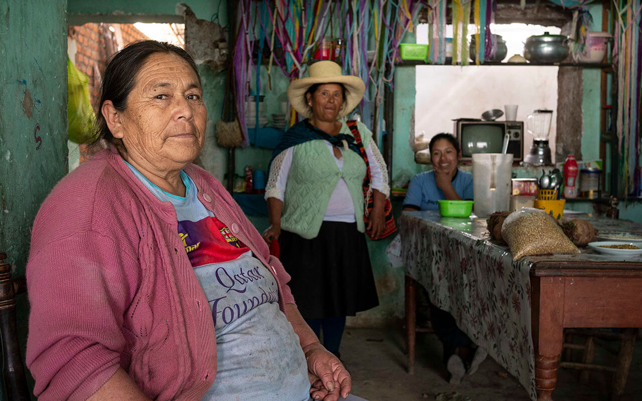 a group of women standing around a kitchen