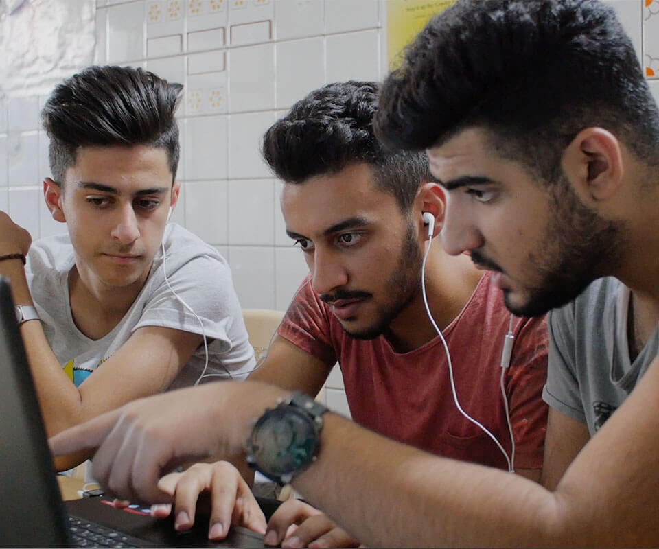 Three young men stare one screen together