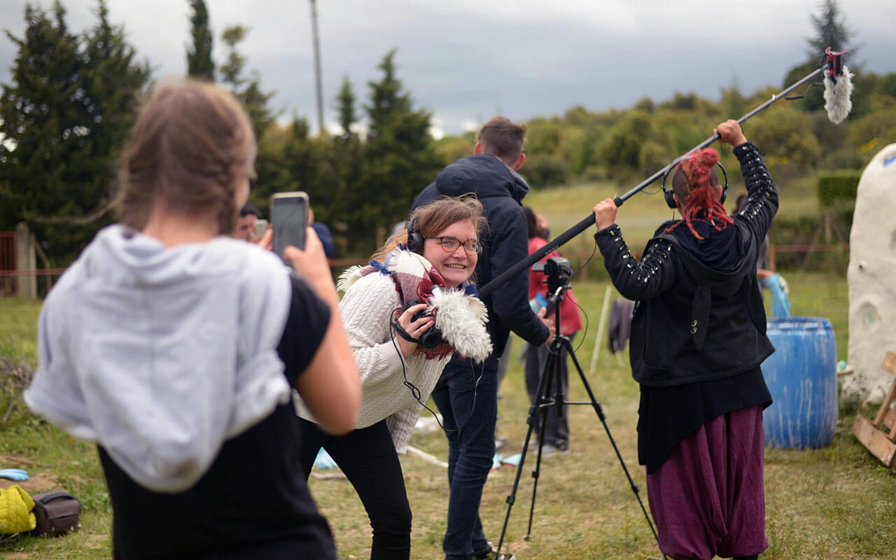 Young women are holding a camera and a long mic